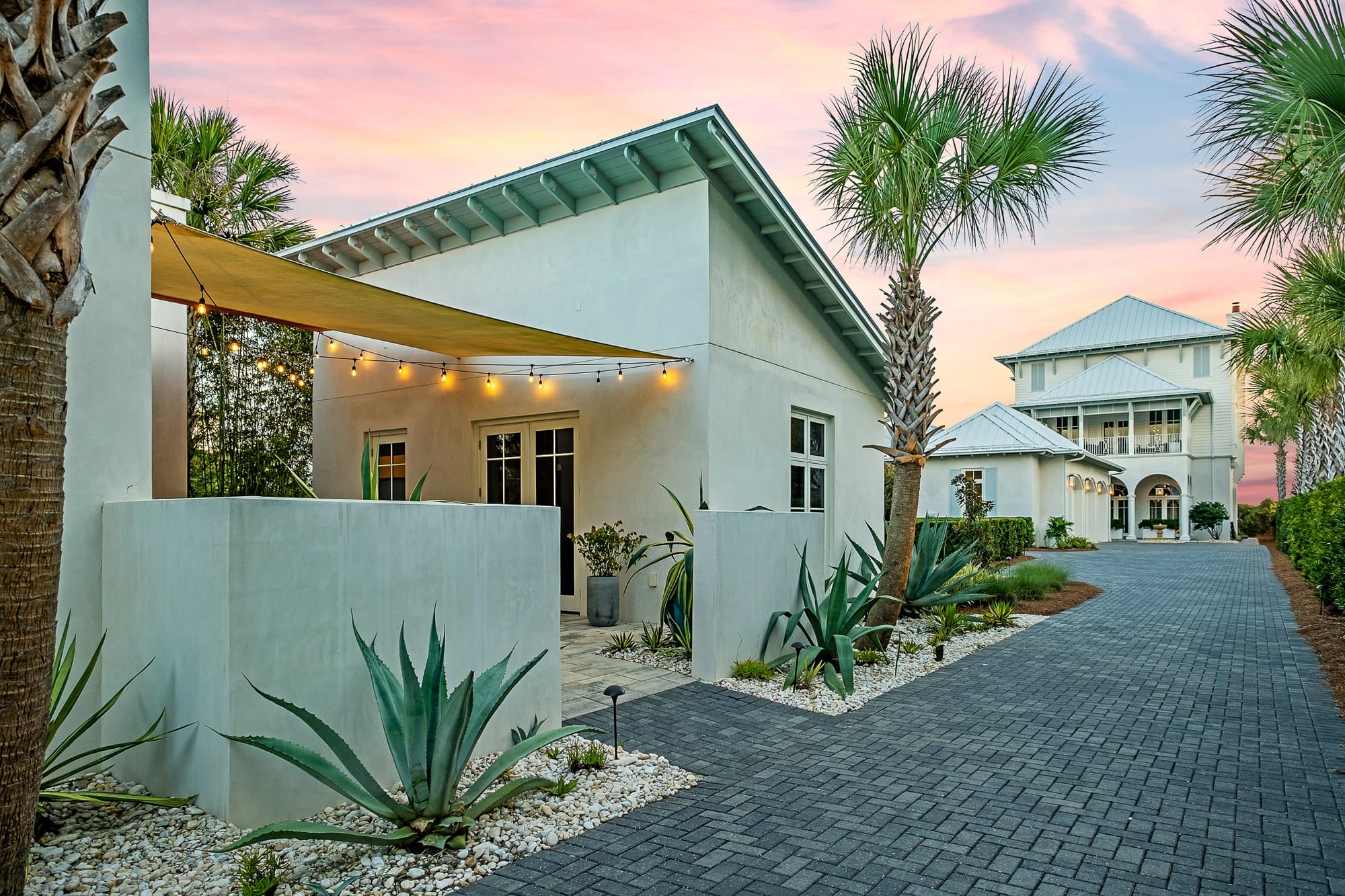 Modern house with palm trees, sunset.