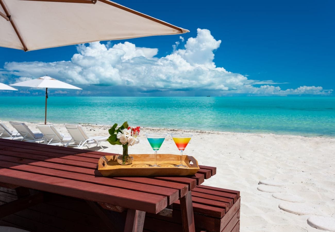 Beach scene with drinks, umbrellas.