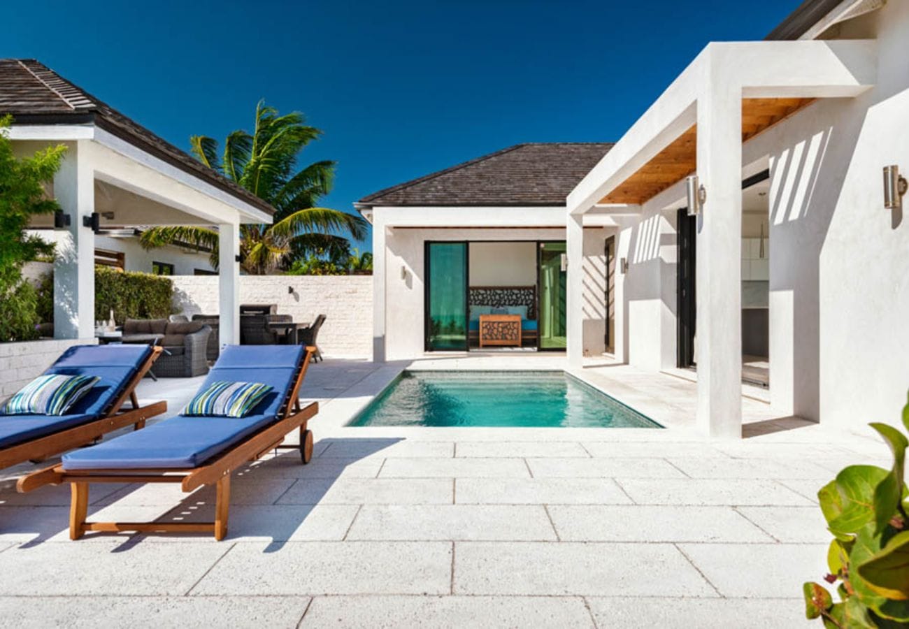 Modern patio with poolside loungers.