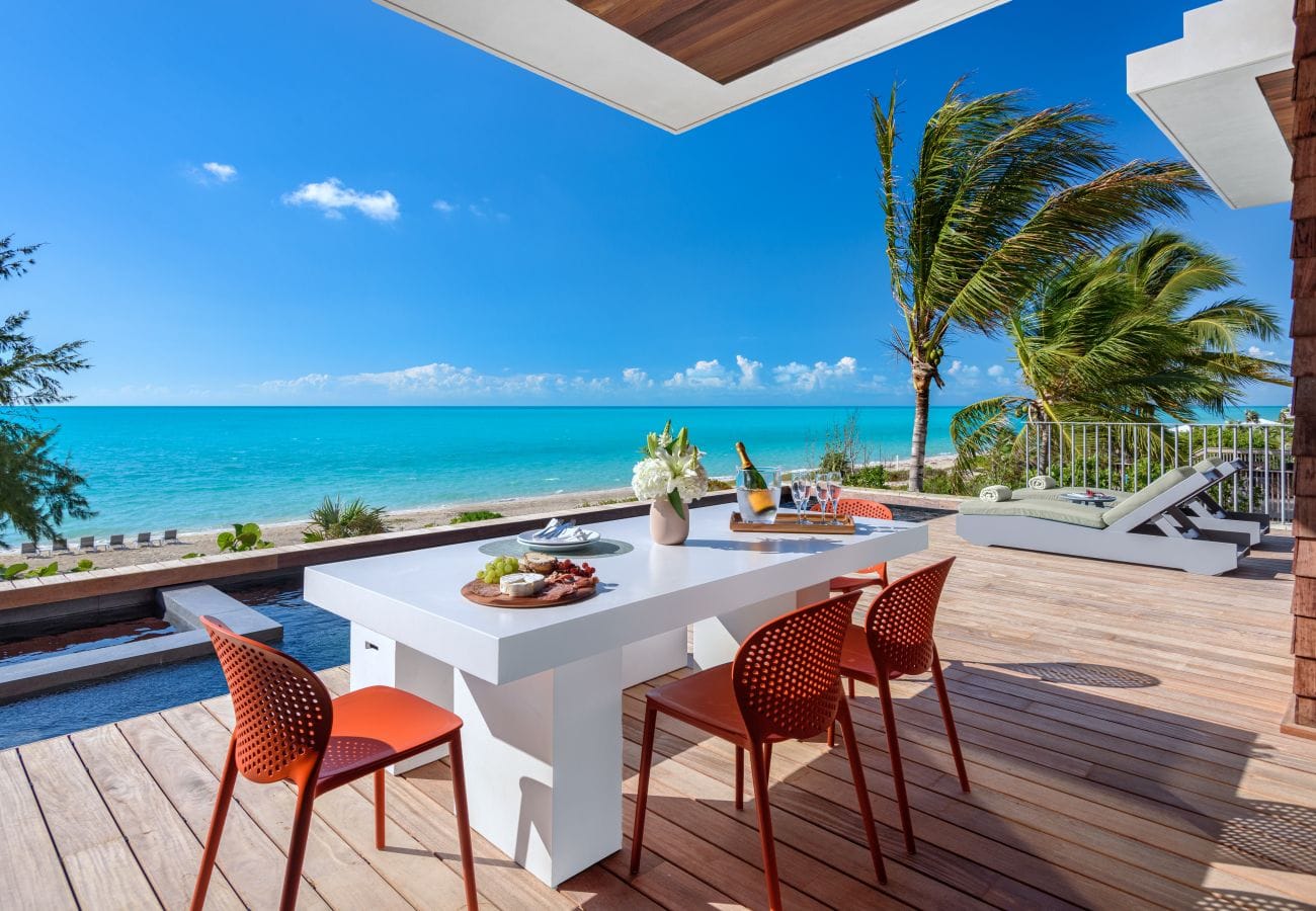 Beachfront deck with dining setup.