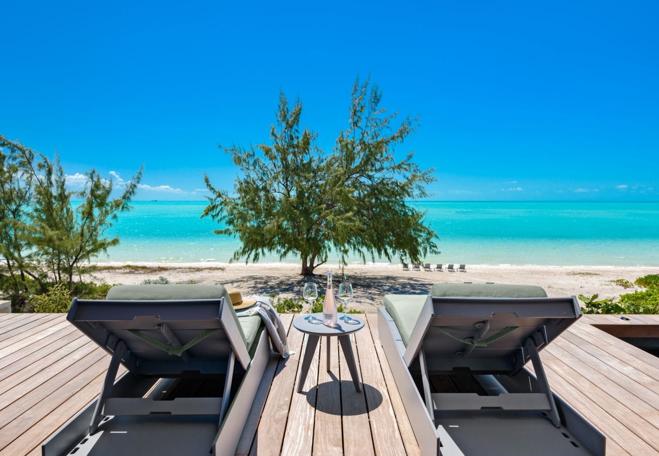 Two lounge chairs facing beach.