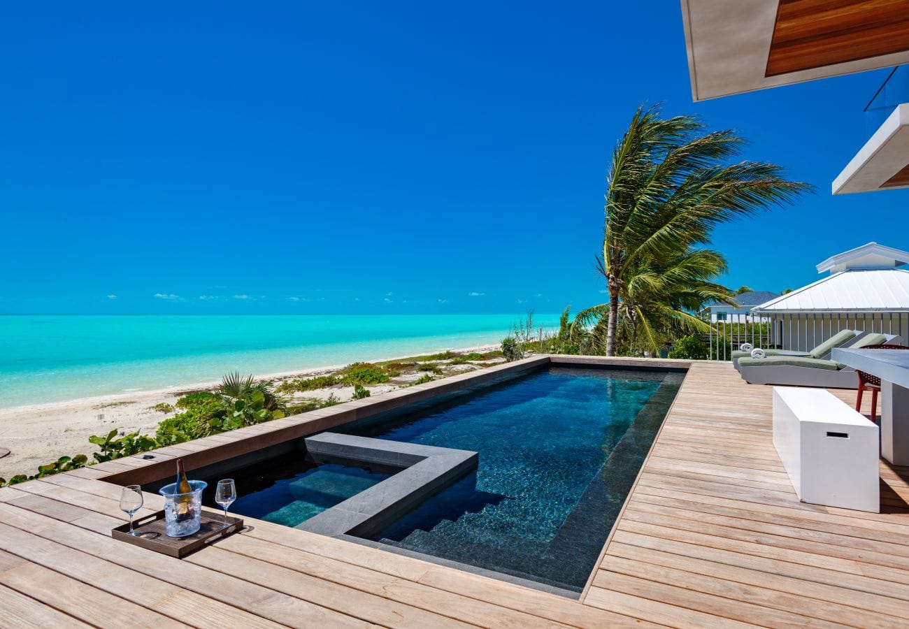 Beachside pool with deck chairs.