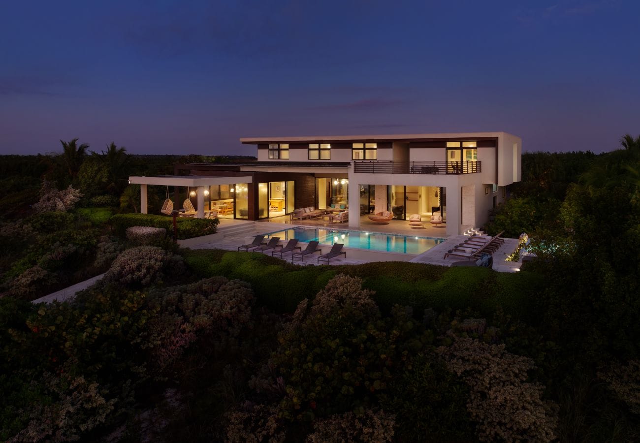 Modern house with illuminated pool.