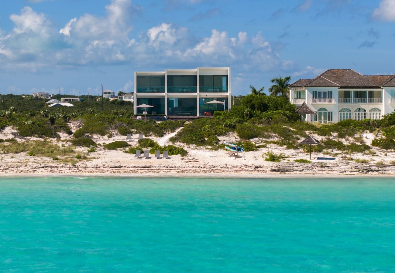 Modern beachfront house with chairs.