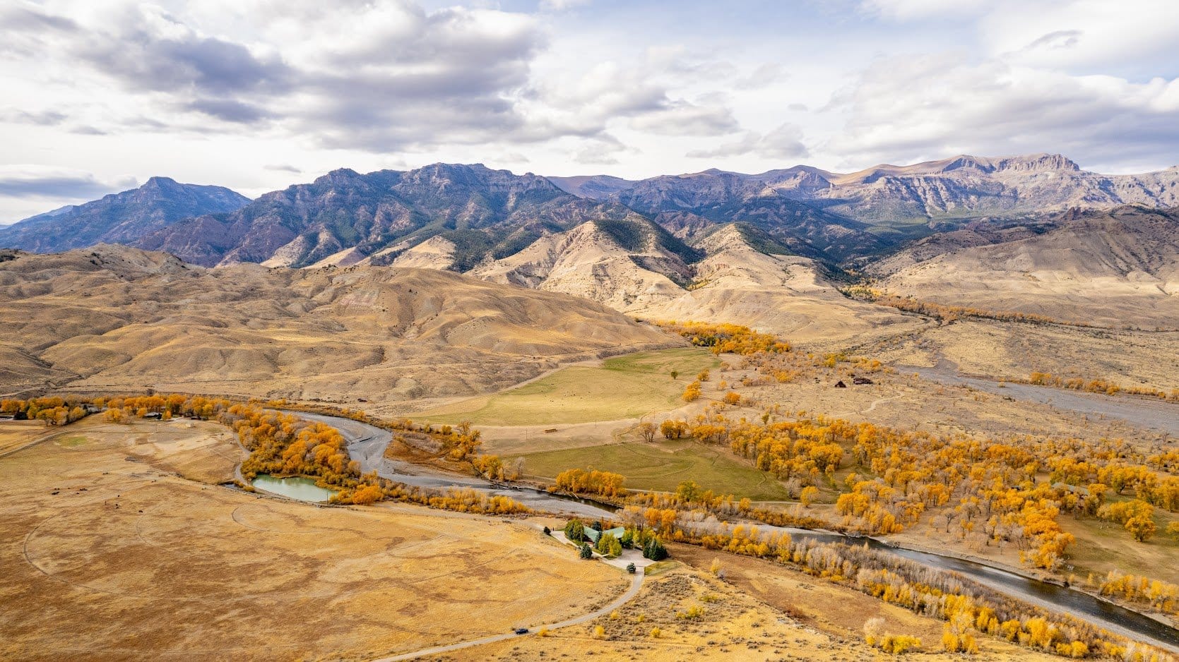 Mountains, river, autumn trees, sky.