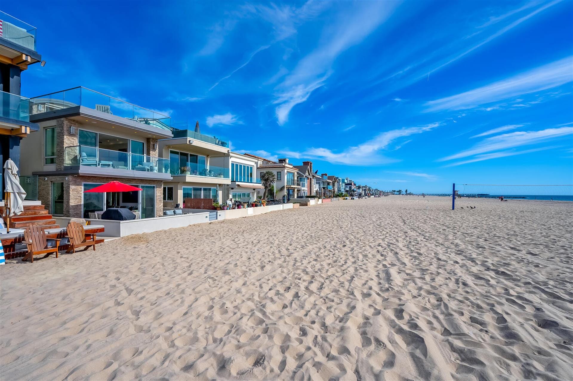 Beachfront homes under clear blue sky.