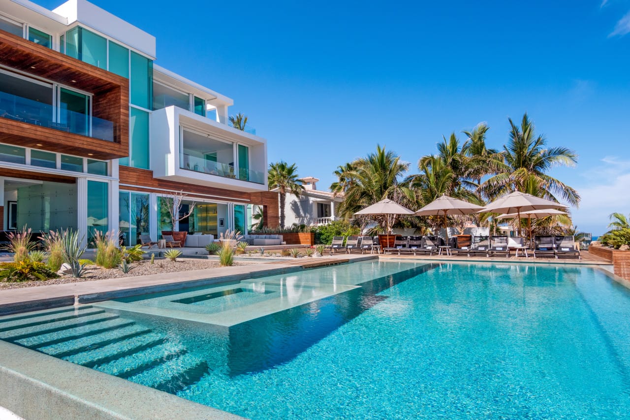 Modern house with pool and palm trees.