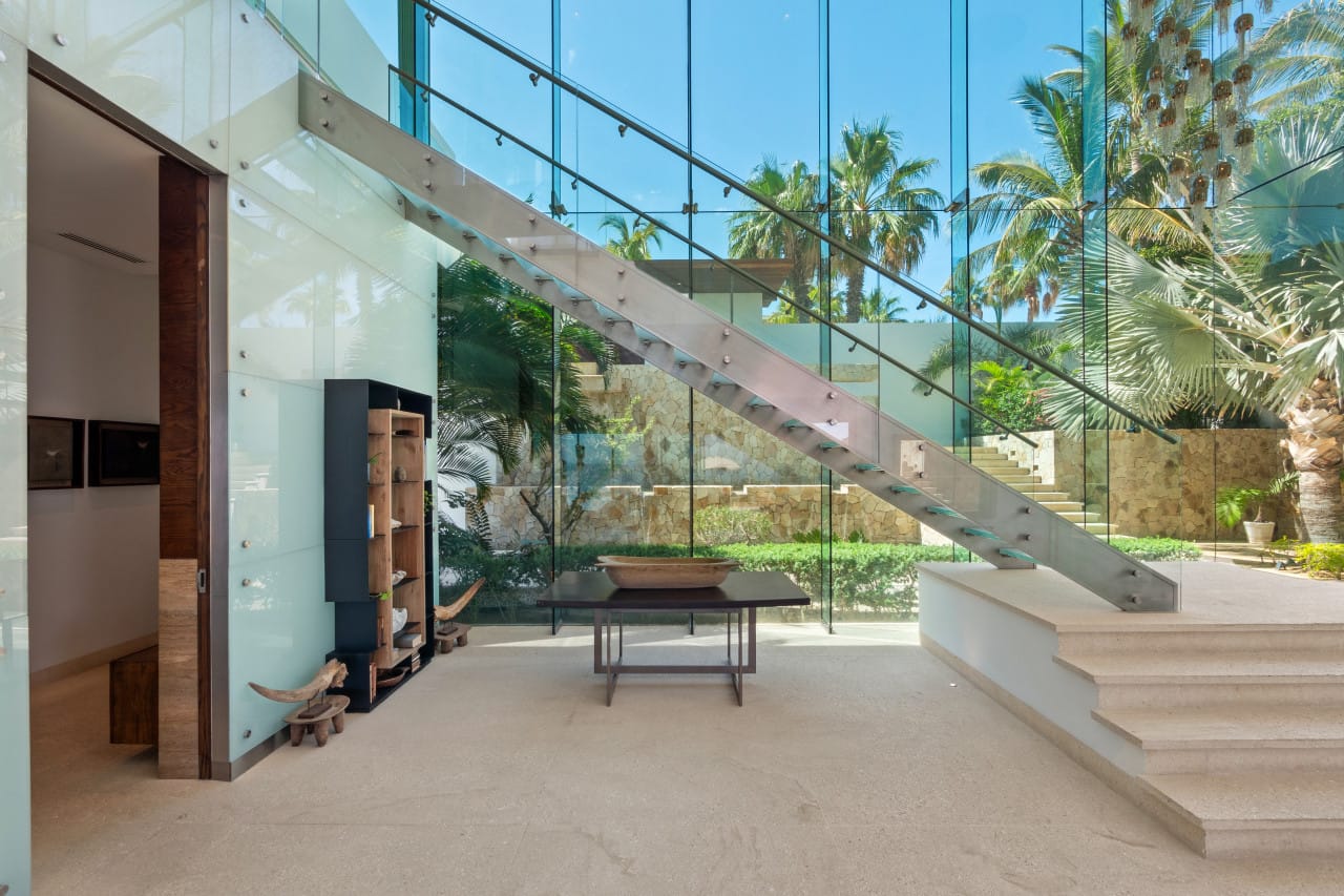 Modern glass-walled staircase with garden.