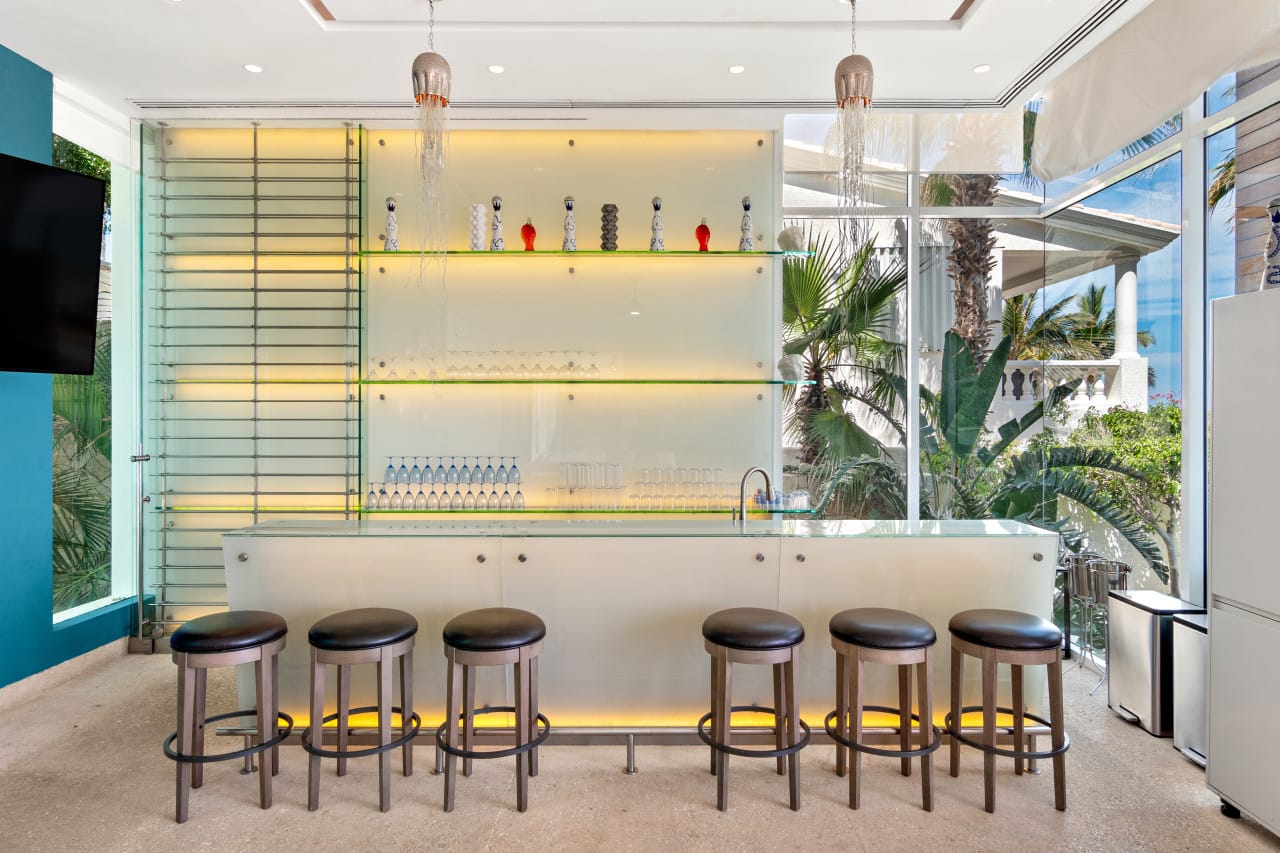 Modern bar with stools and shelves.