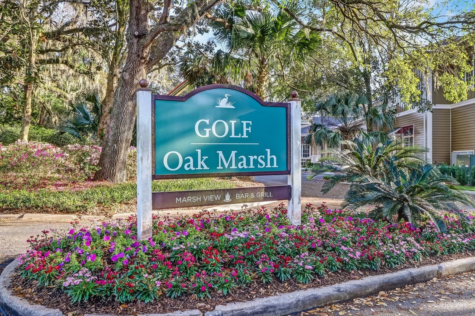 Golf course sign with flowers.