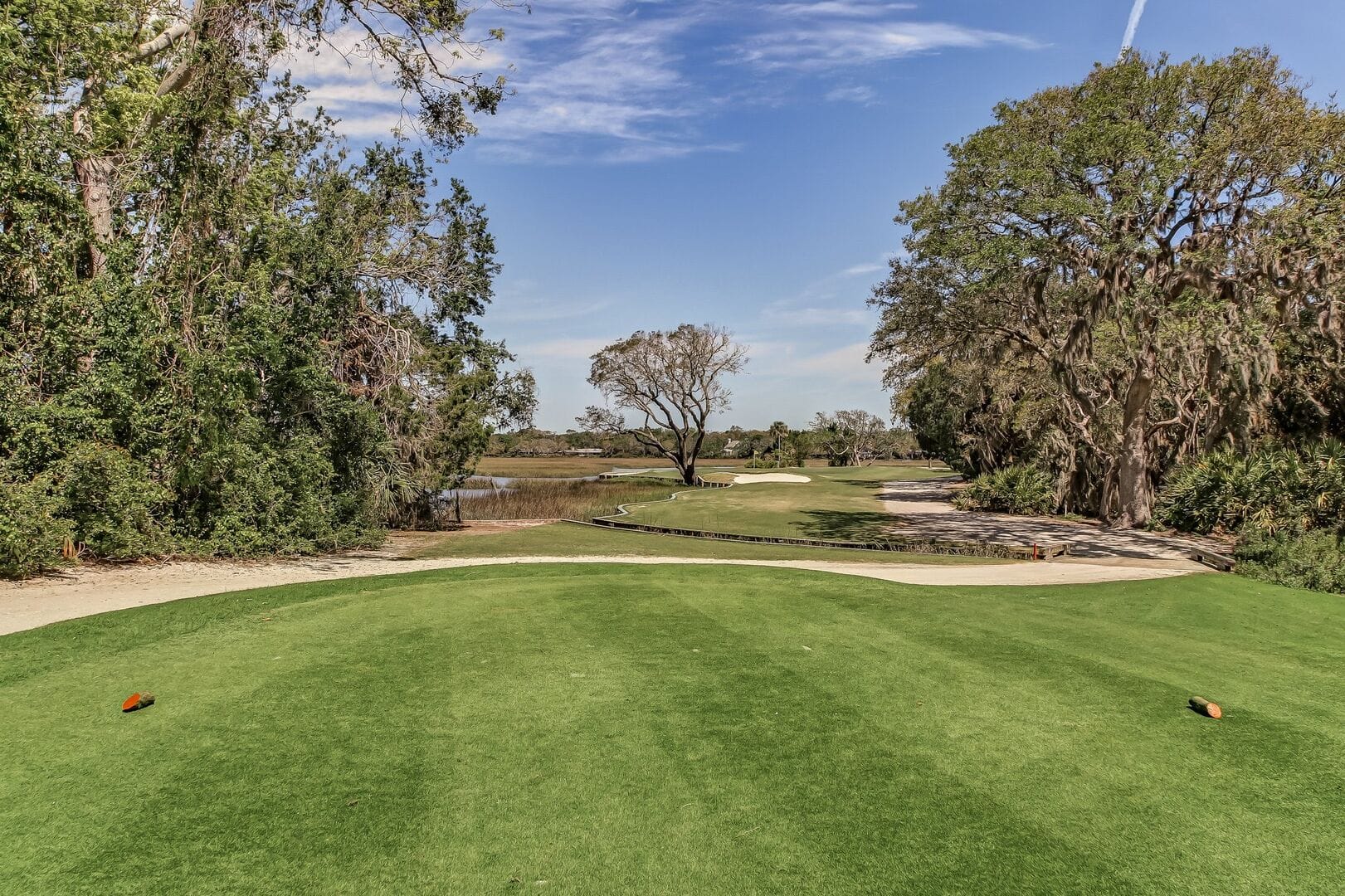 Golf course with trees and sky.