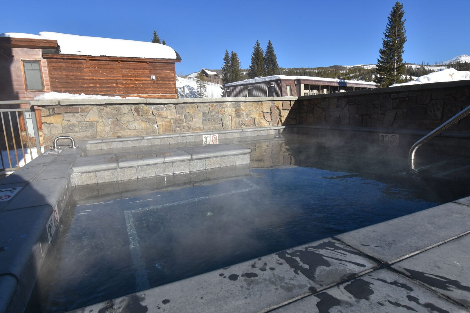 Steaming outdoor hot tub in snow.