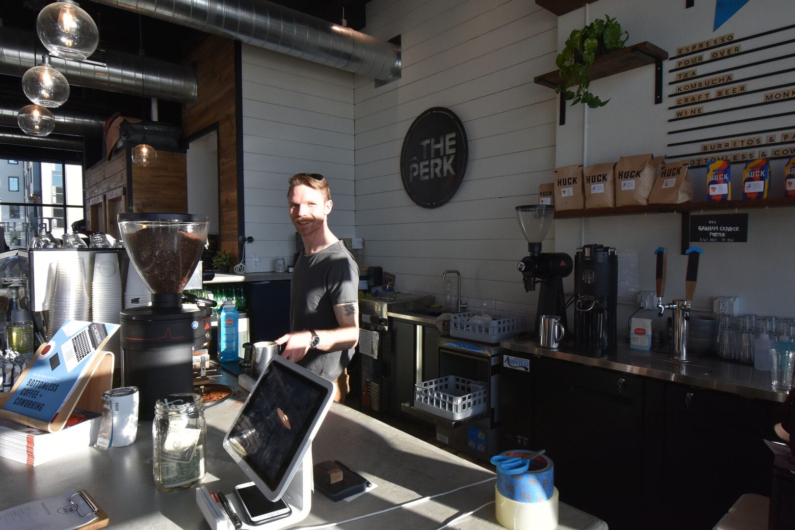 Barista smiling at coffee counter.