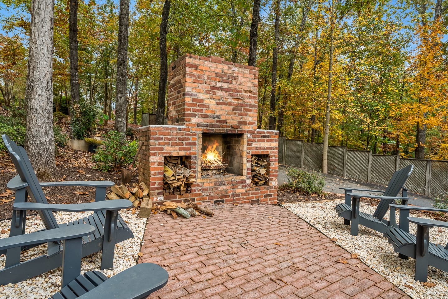 Outdoor fireplace with surrounding chairs.