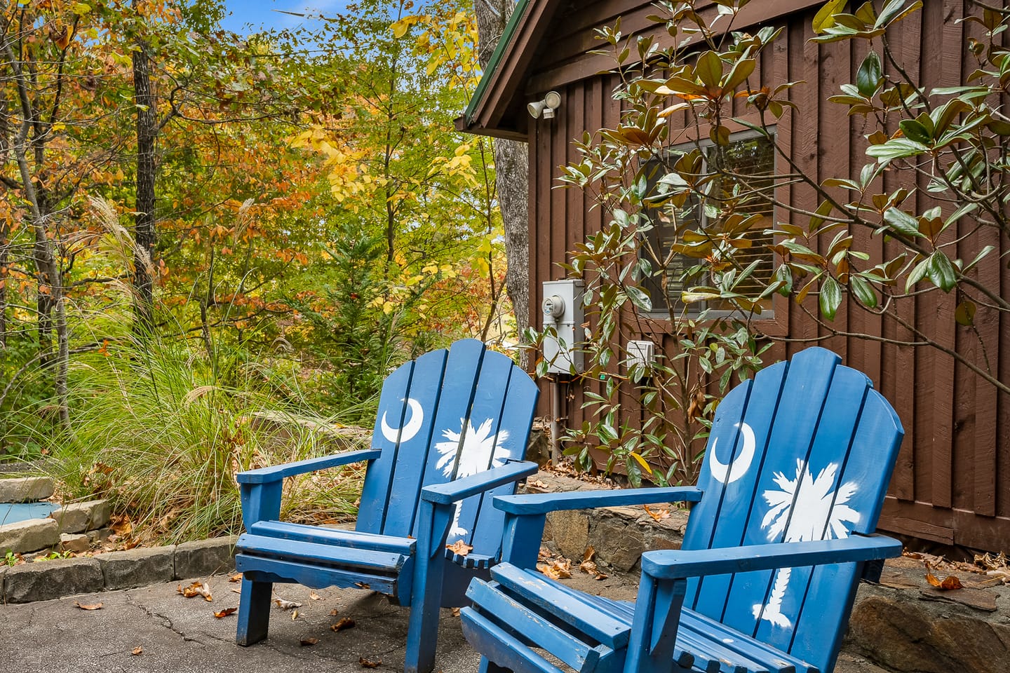 Blue chairs by rustic cabin.