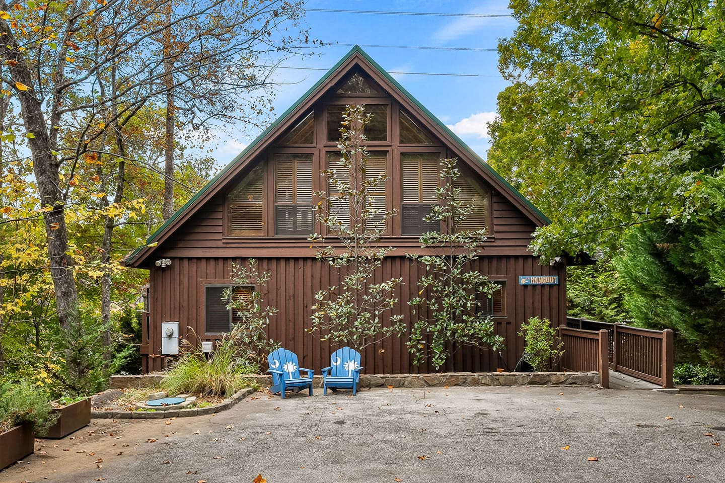 A-frame cabin with blue chairs.