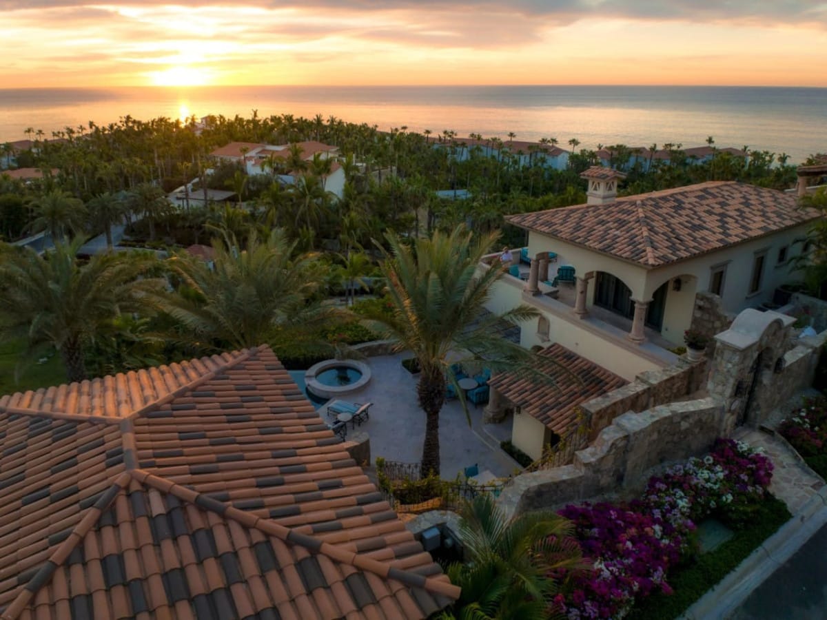 Sunset over Mediterranean-style villa, ocean.