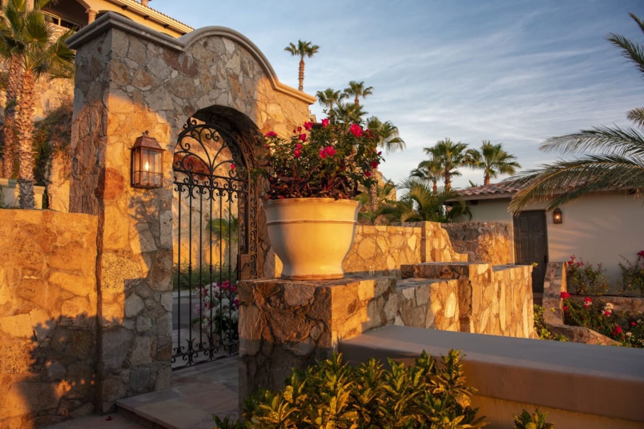 Stone gate with potted flowers.