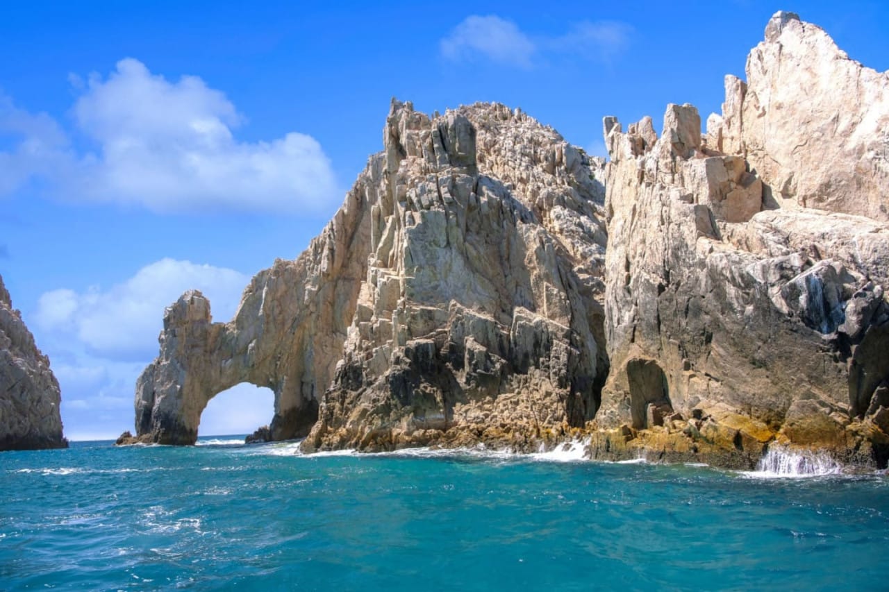 Rocky arch over blue ocean.