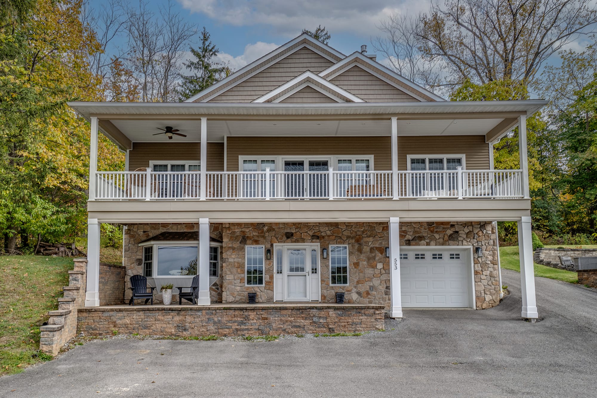 Two-story house with stone facade.