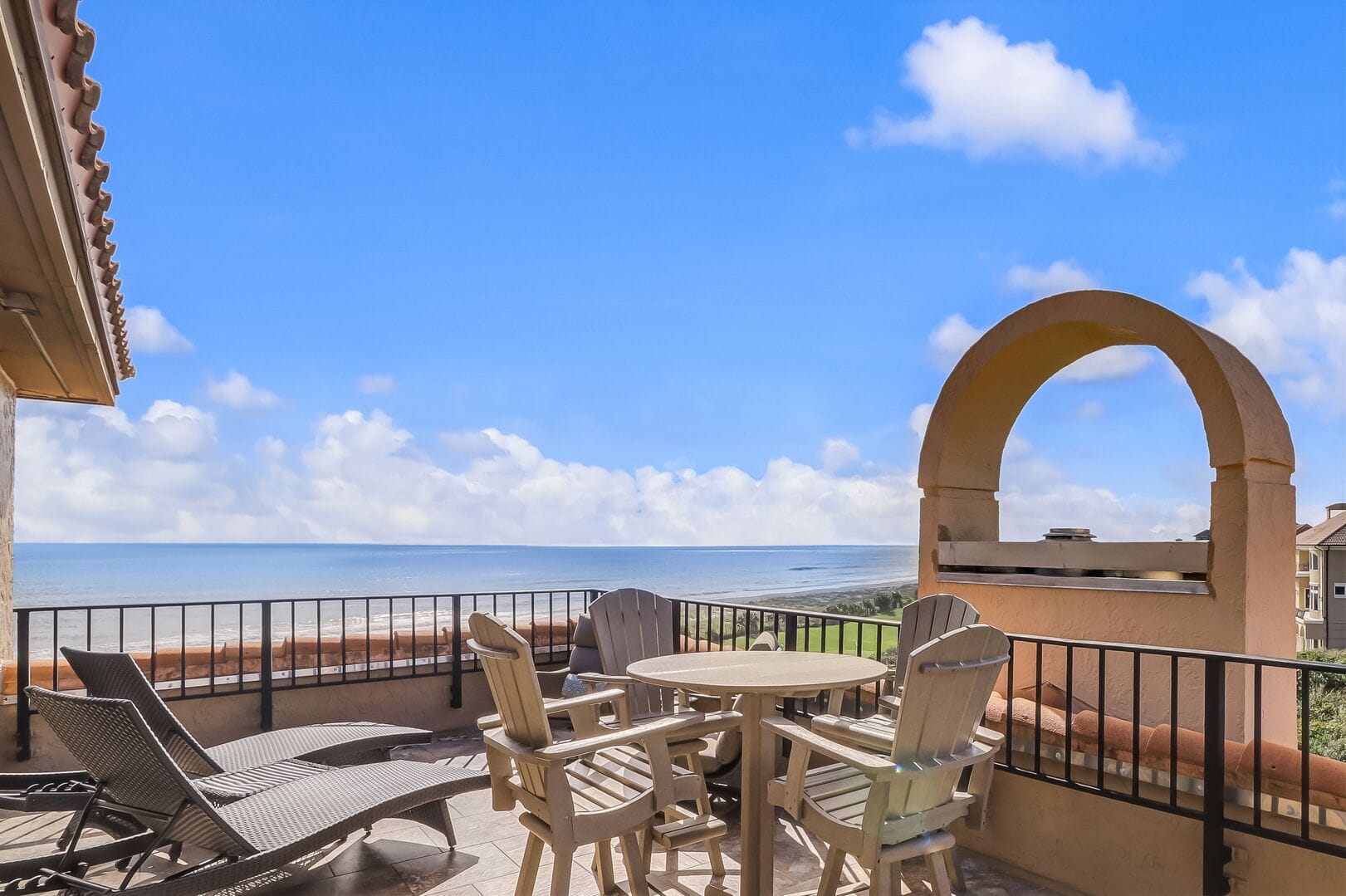 Balcony with ocean view, outdoor furniture.