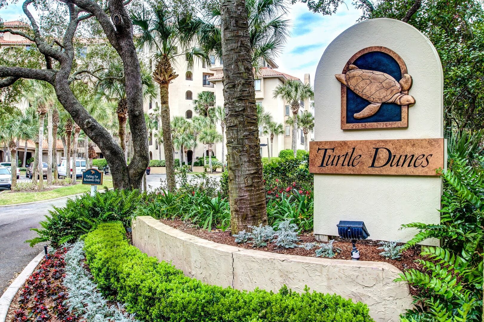 Turtle Dunes sign amidst greenery.