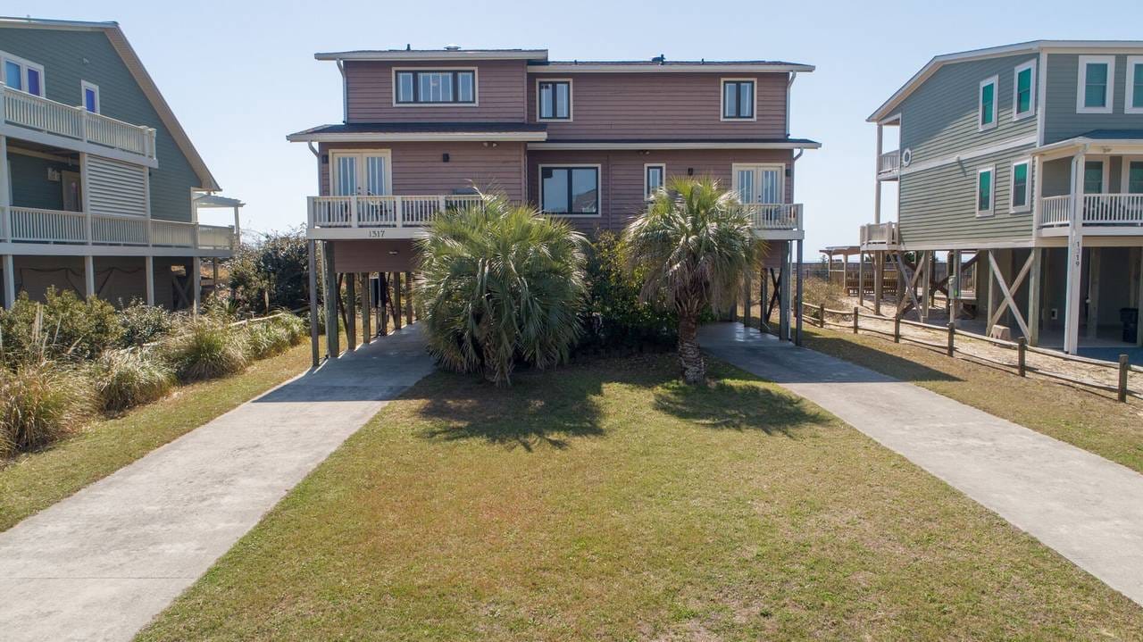 Elevated beach house with palm trees.