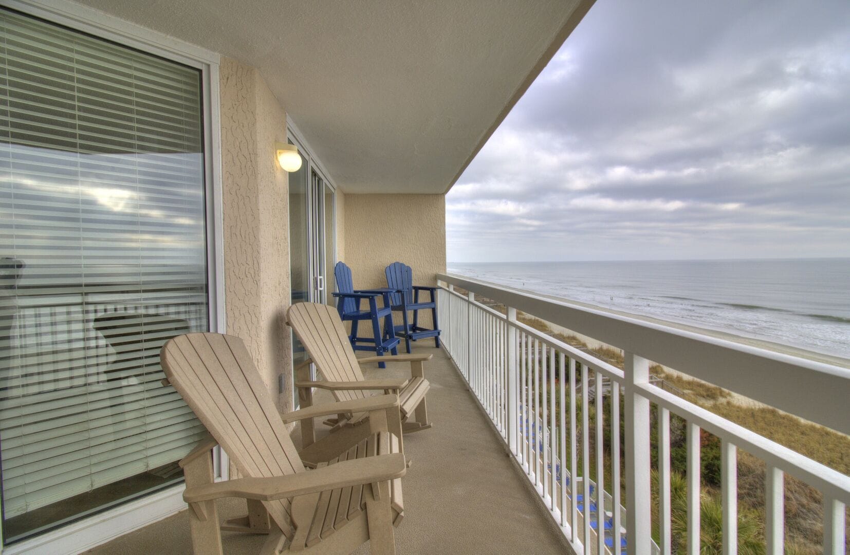 Beachfront balcony with Adirondack chairs.