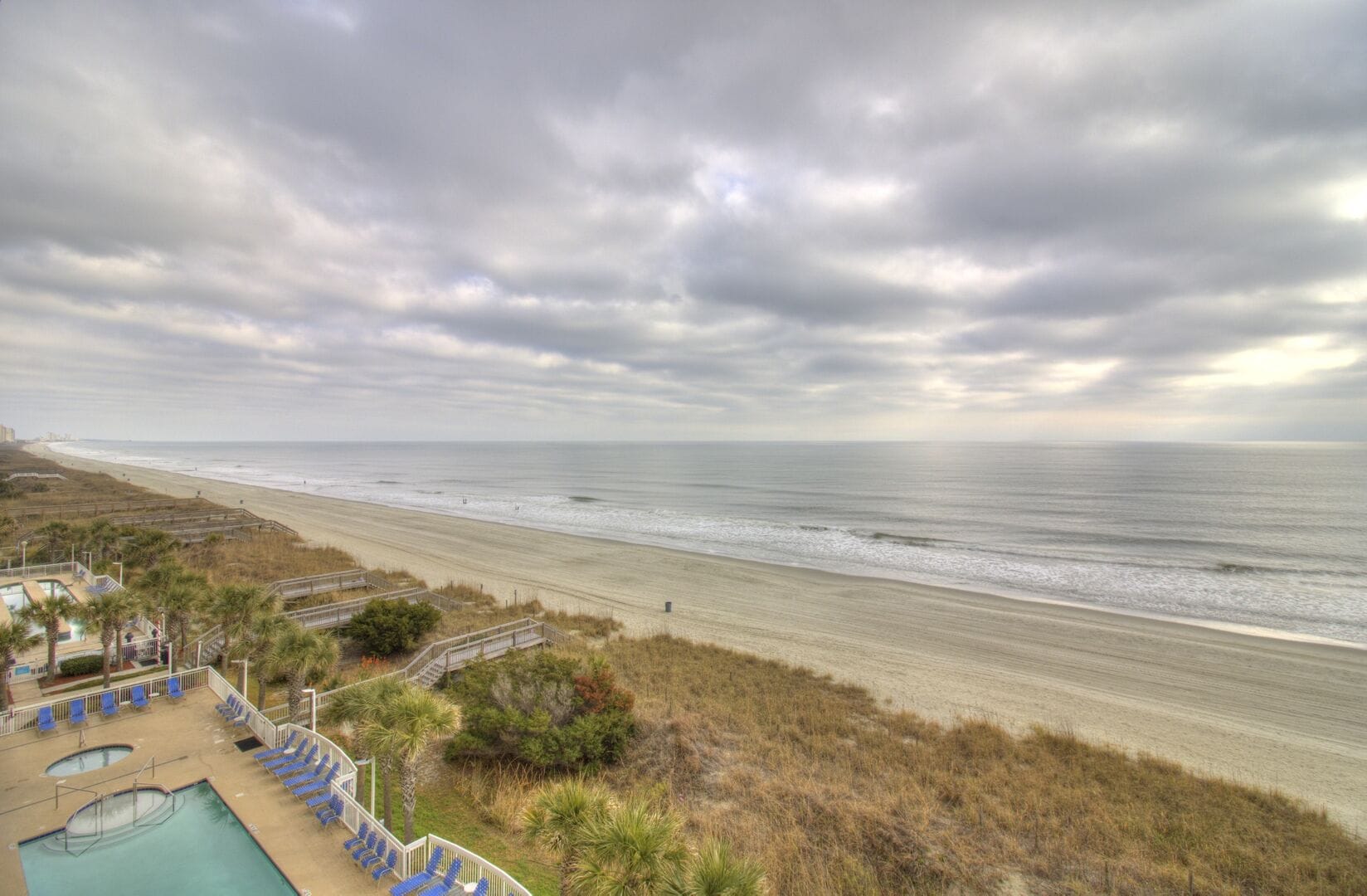 Cloudy beach with pools, ocean.