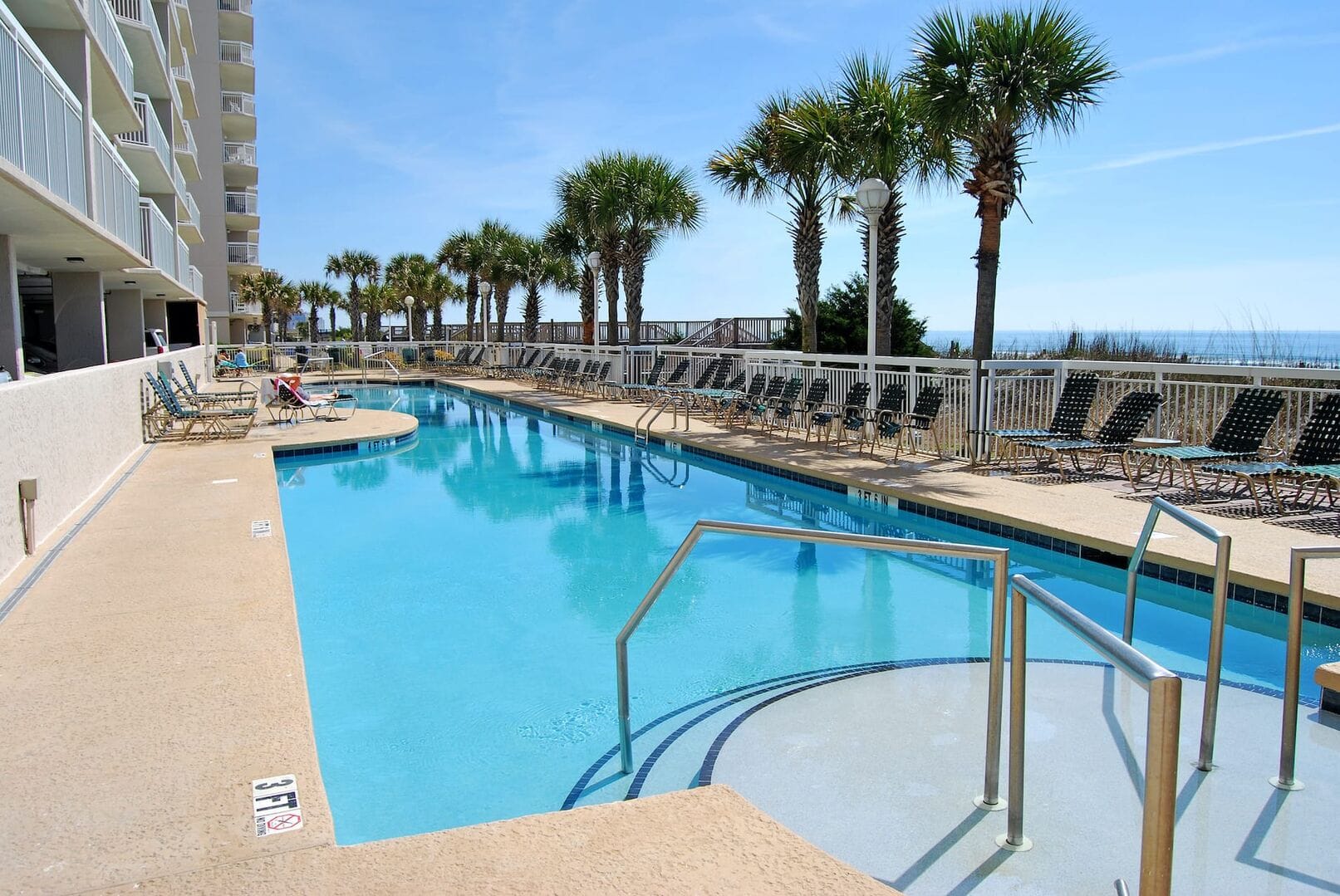 Outdoor pool with palm trees.