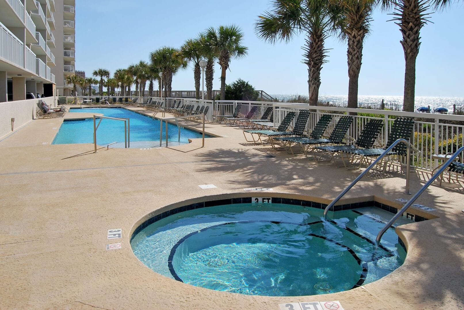 Outdoor pool and spa near beach.