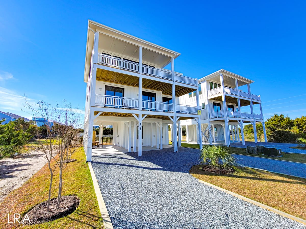 Two white beach houses, sunny day.