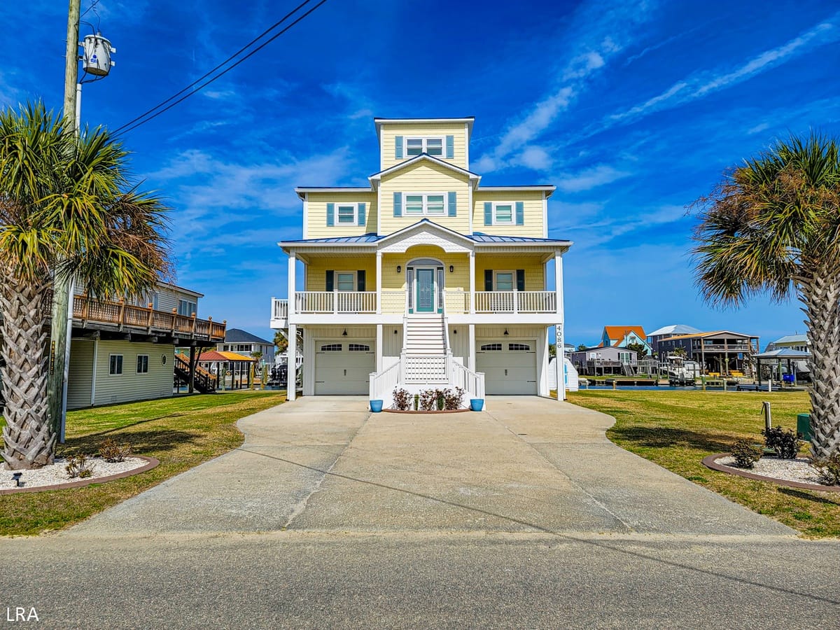 Yellow house with palm trees.