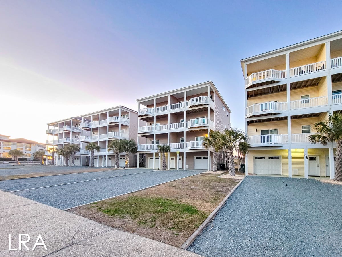 Three-story beachfront condominiums at sunset.