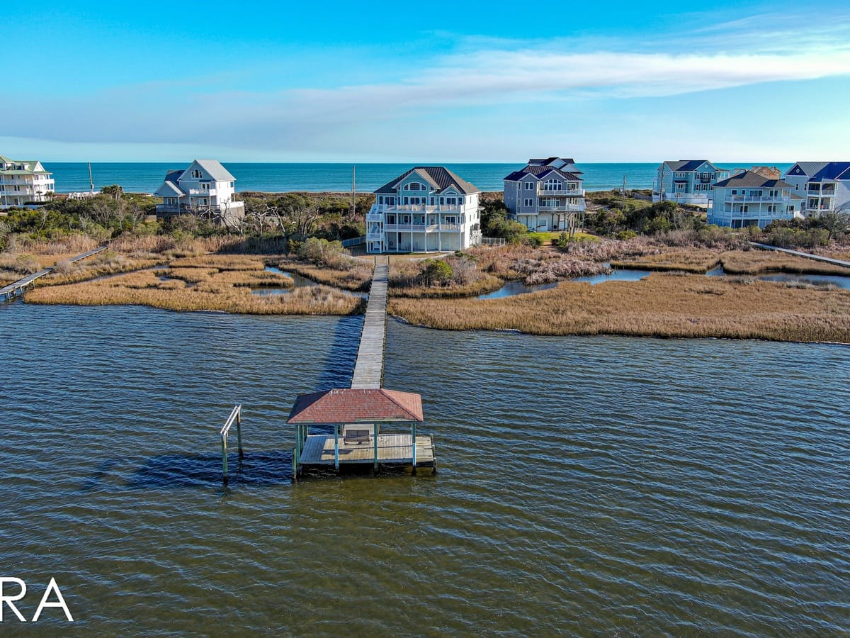 Coastal houses with pier over water.