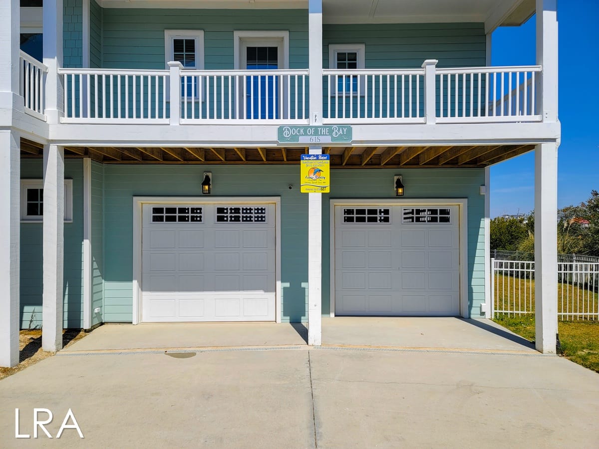 Two-story house with garage doors.