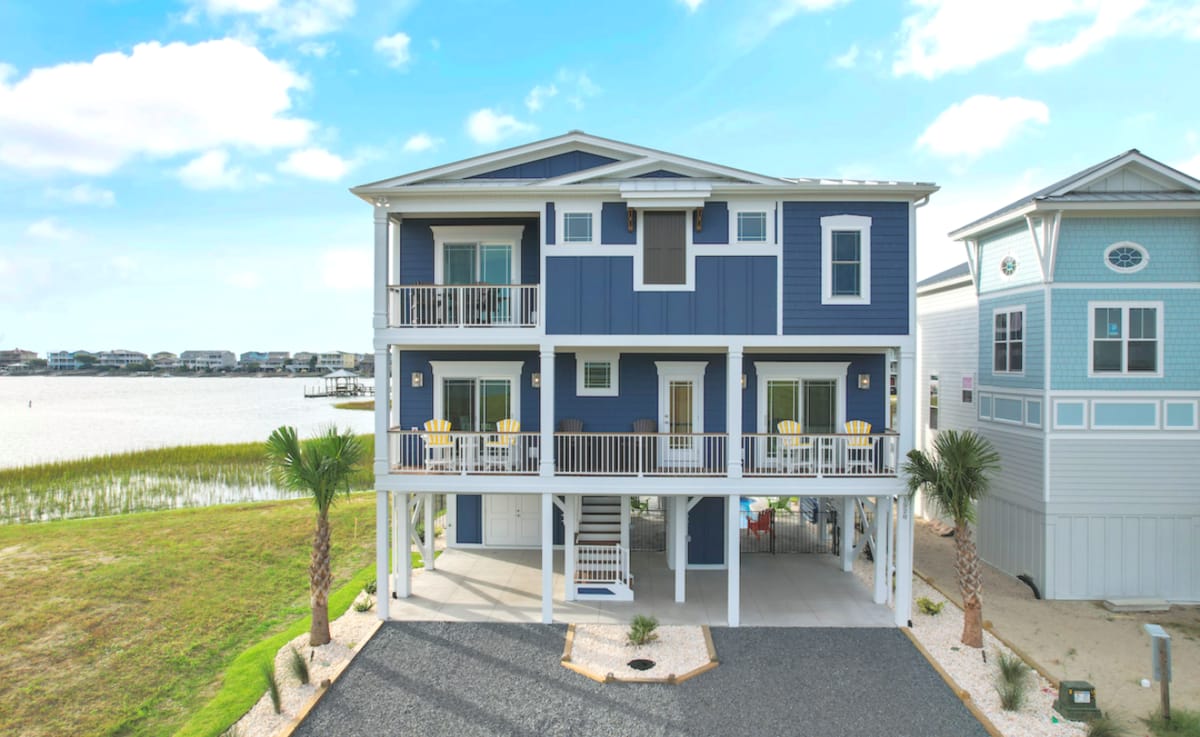 Blue stilt house by water.