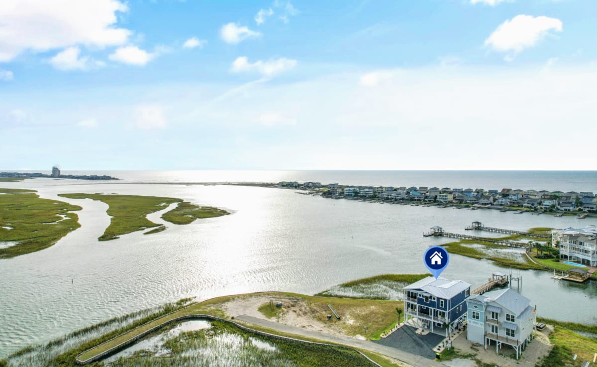 Coastal houses near marsh and water.