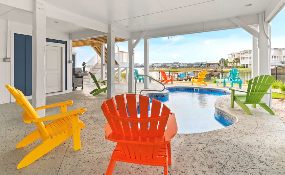 Colorful chairs around small pool.