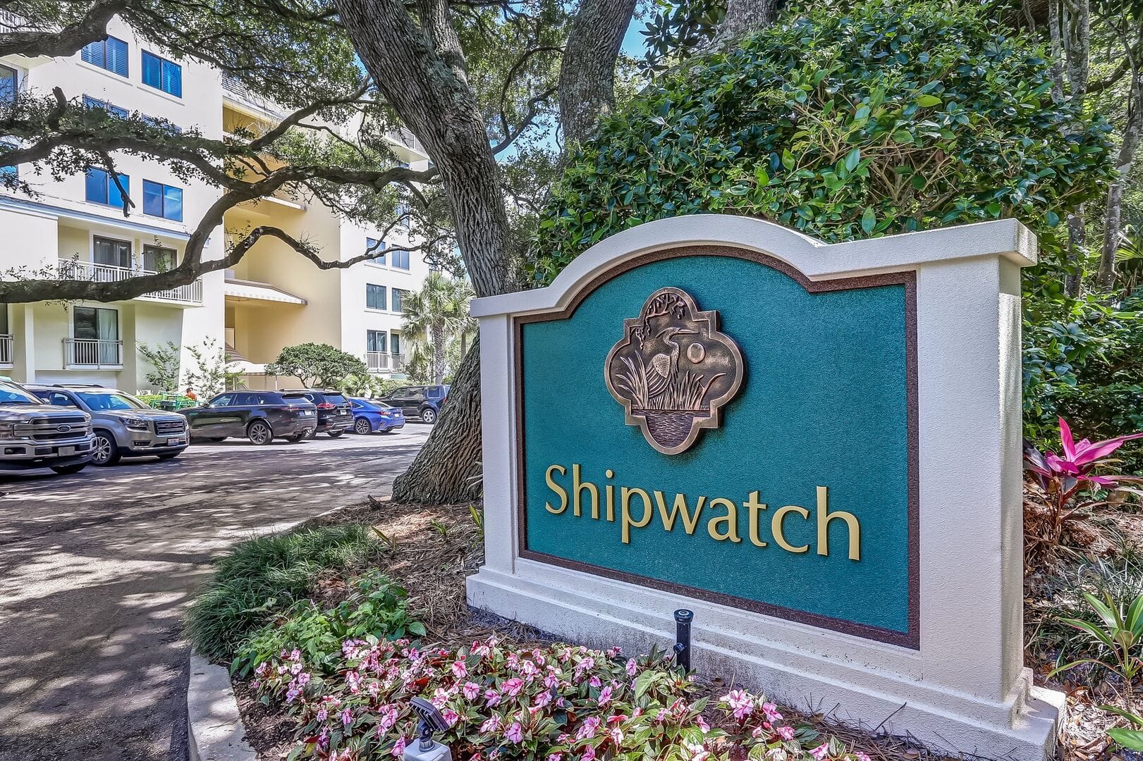 "Shipwatch sign near buildings, trees."