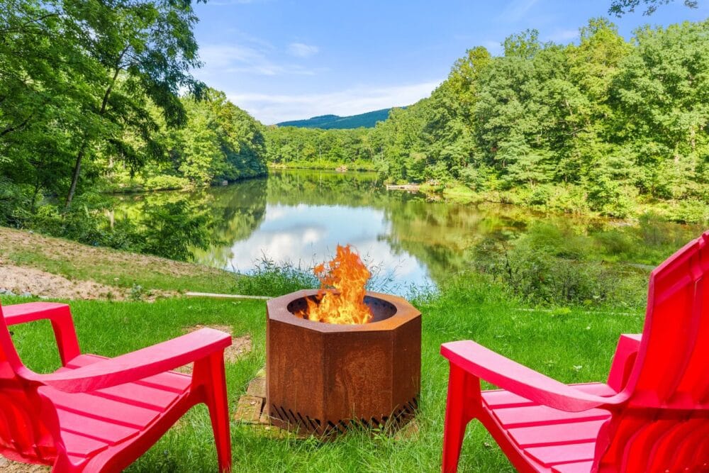 Red chairs by lakeside firepit.