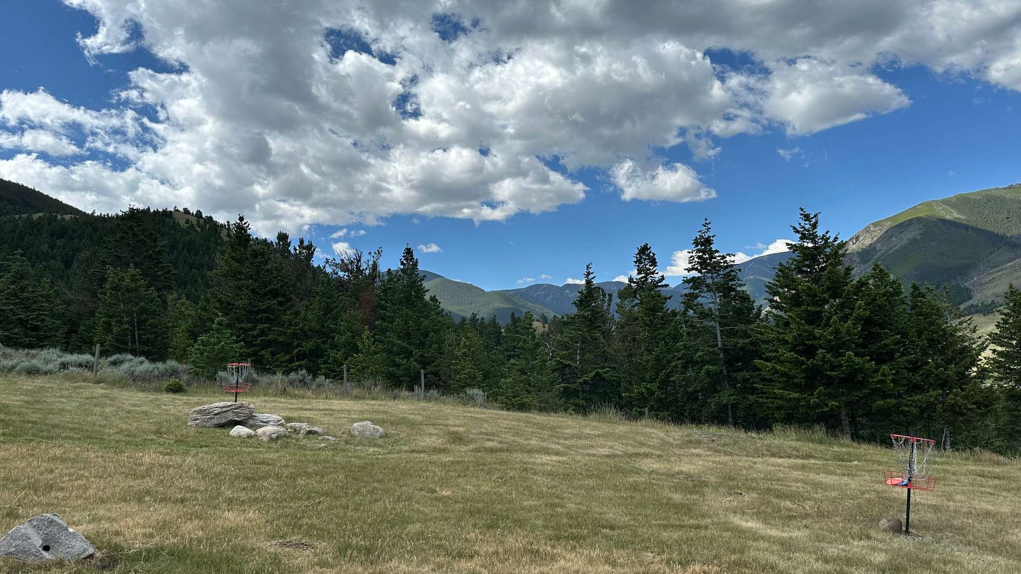 Mountainous landscape with disc golf basket.