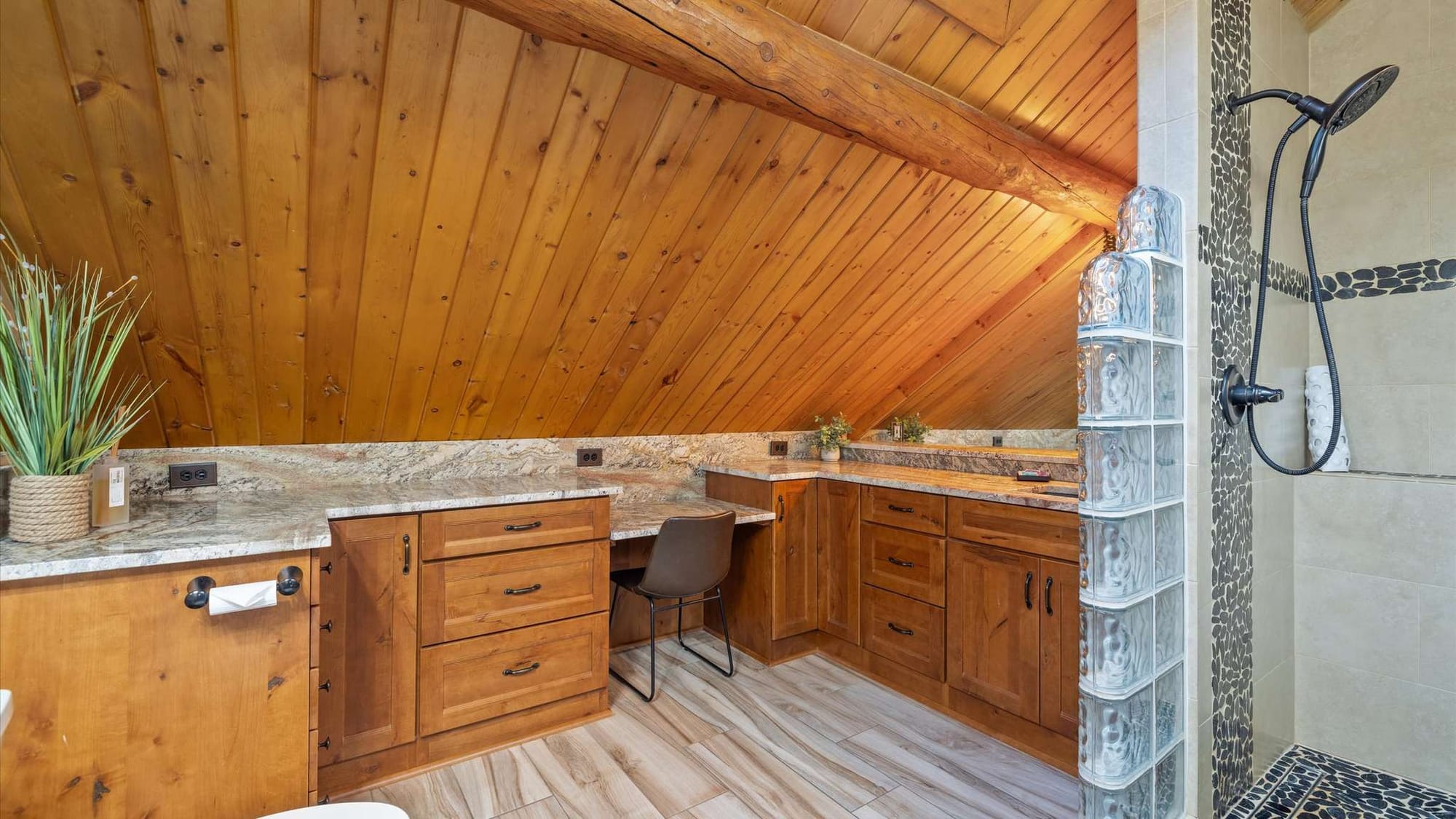 Rustic bathroom under sloped ceiling.