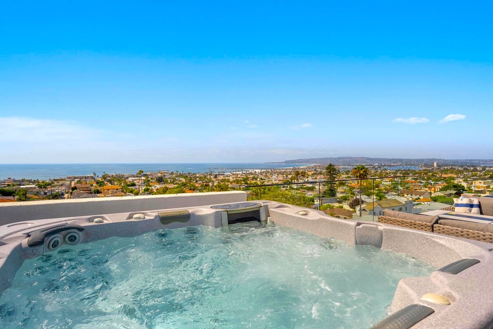 Hot tub overlooking coastal cityscape.