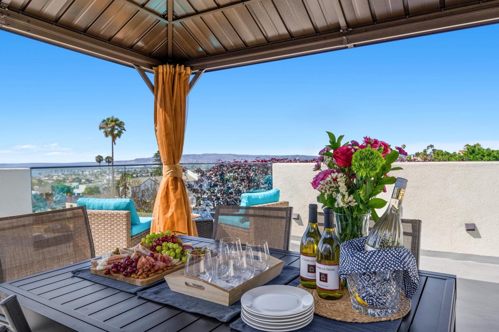 Outdoor dining table with drinks, flowers.