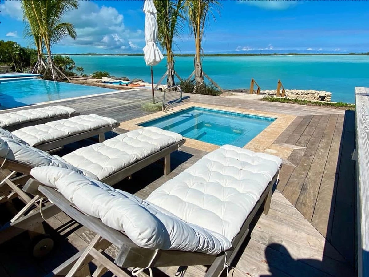 Sun loungers by tropical pool.