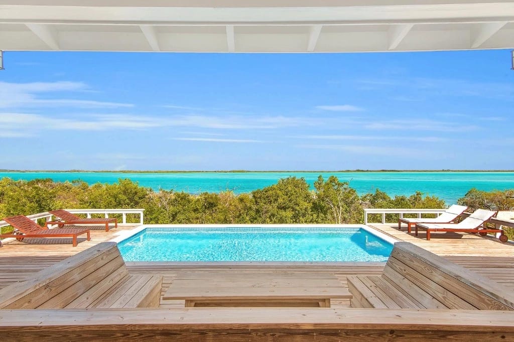 Pool with ocean view and loungers.