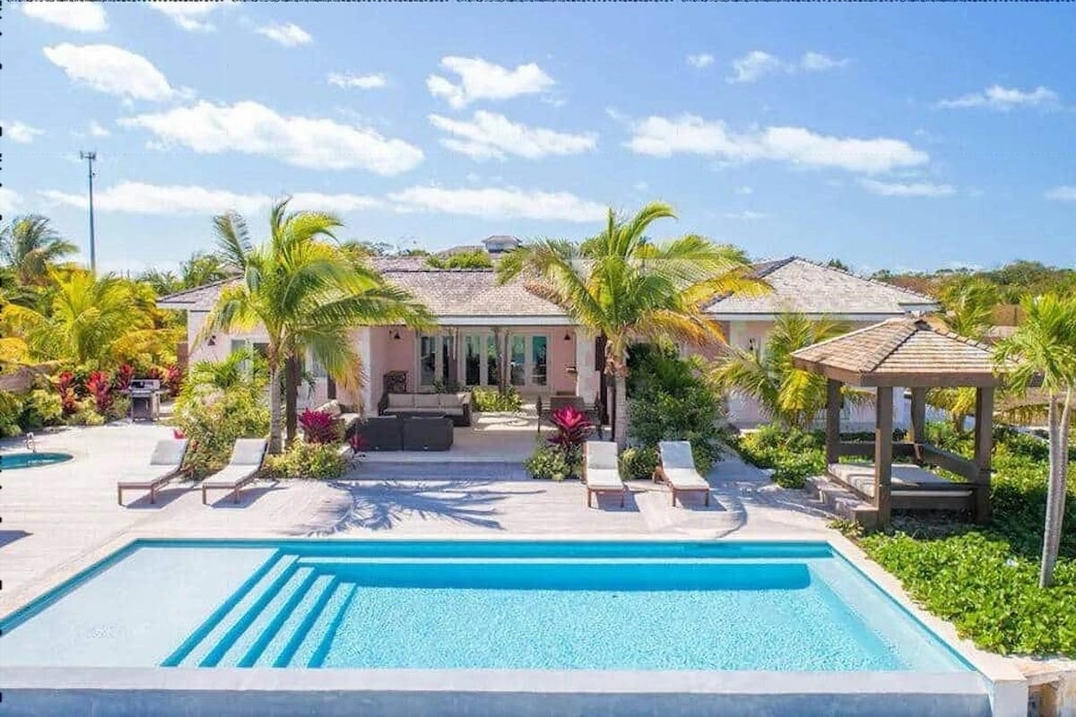 Luxurious villa with pool, palm trees.