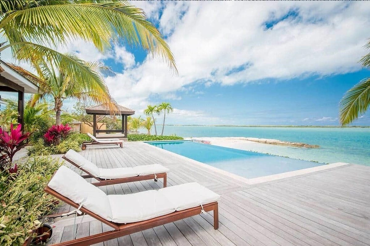 Tropical poolside with lounge chairs.