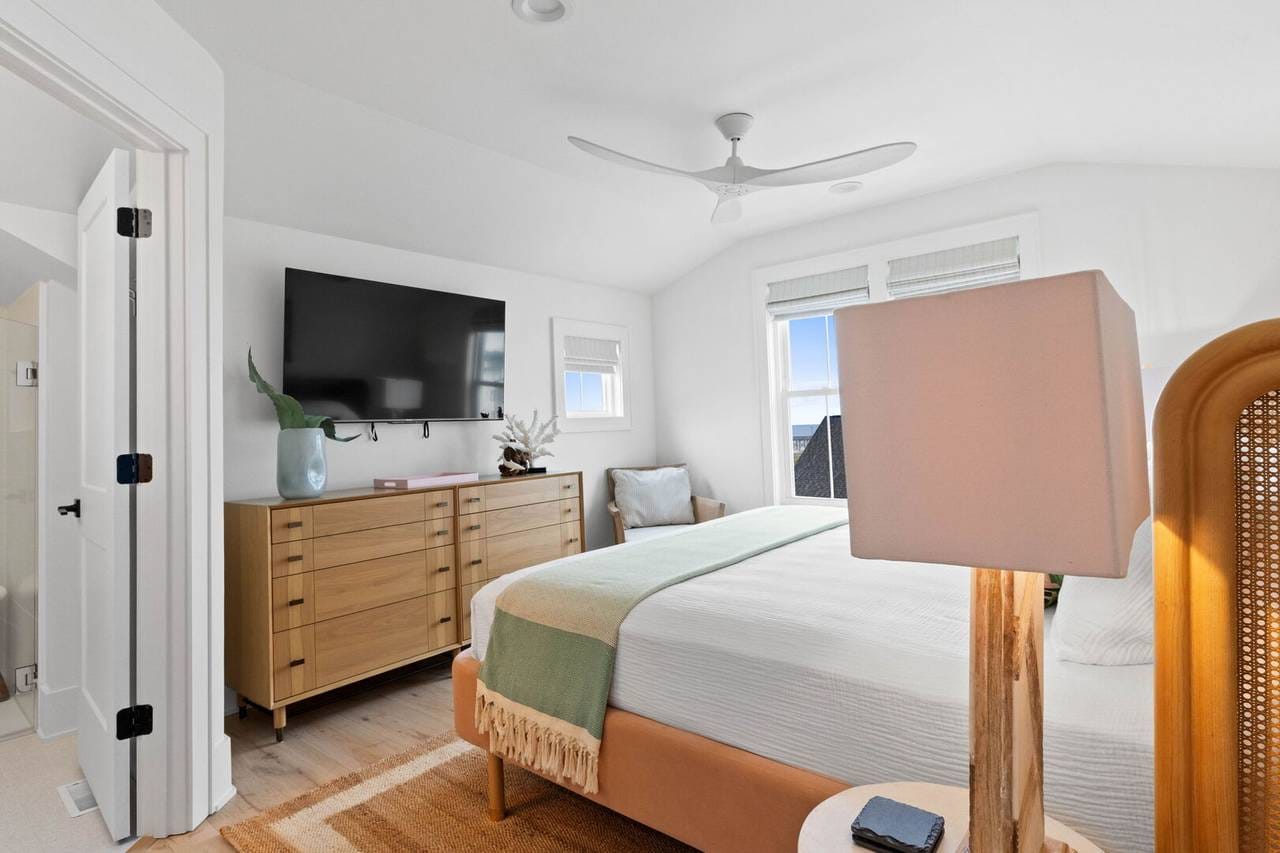 Modern bedroom with TV and dresser.